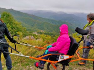 La sedia a rotelle di montagna, la joelette, su un percorso accessibile di montagna